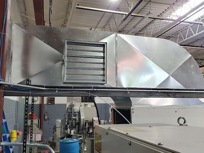 A ventilation system is installed on the side of a building in a factory.