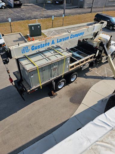 A truck with a crane attached to it is carrying a large box.
