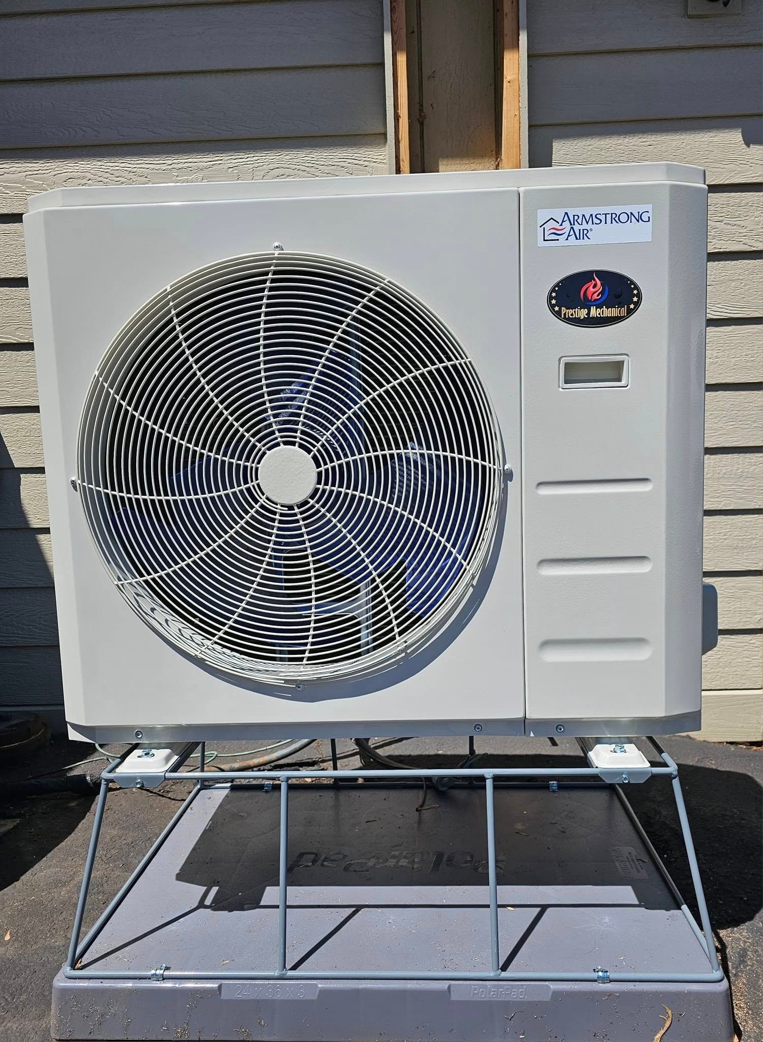 A white air conditioner is sitting on a metal stand
