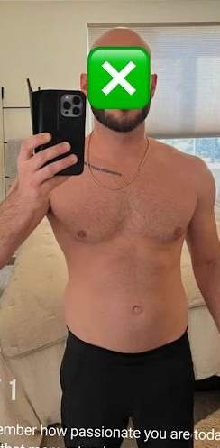 A shirtless man with a green X emoji covering his face. He's holding a phone, wearing black pants, in a bedroom.
