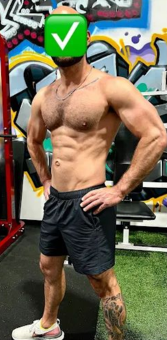 Muscular man with green checkmark head poses in gym, wearing shorts and sneakers. Graffiti background.