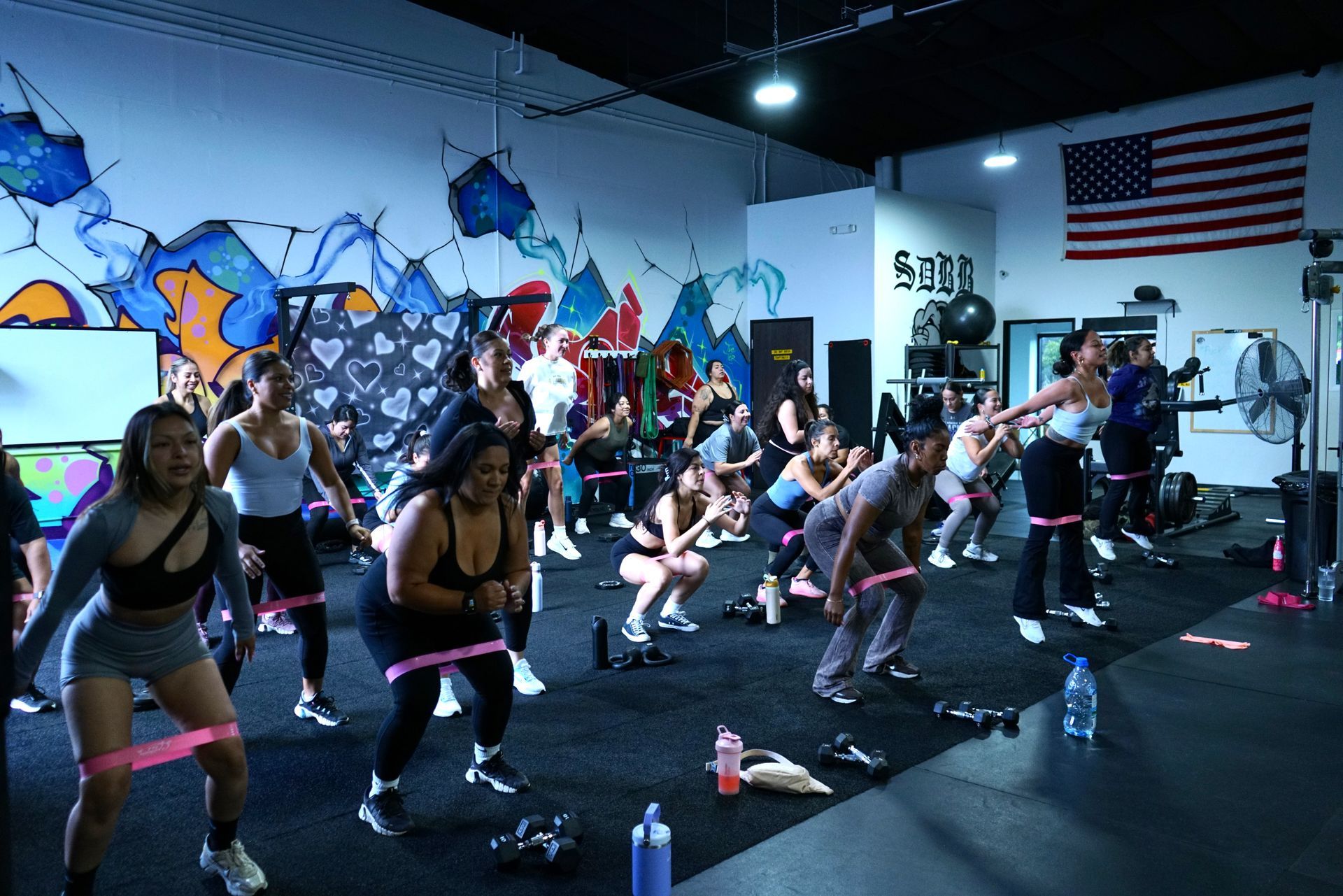 People lifting barbells in a gym. Man and woman bend over the weight, preparing to lift.