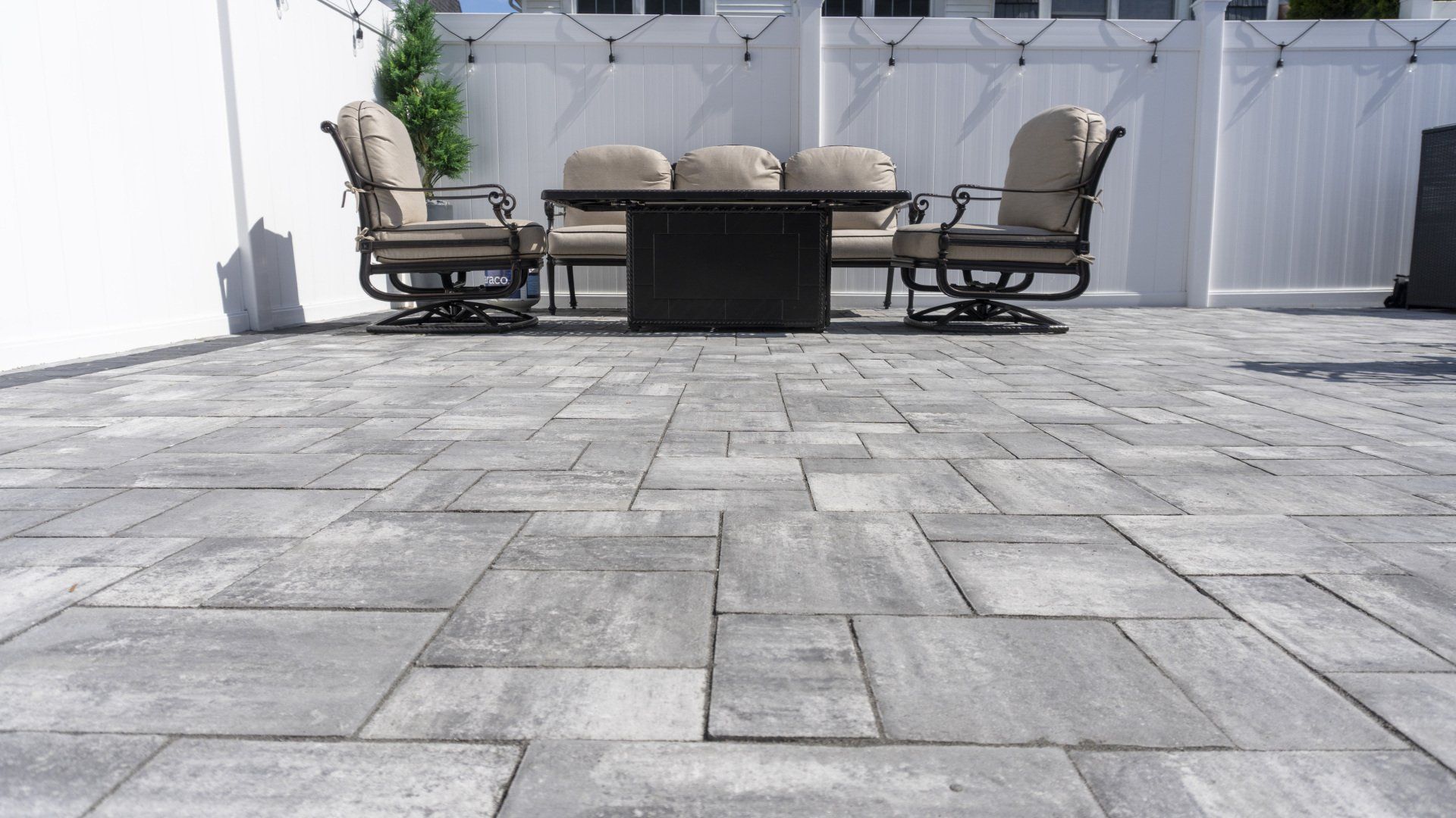 A patio with a table and chairs and a fire pit.