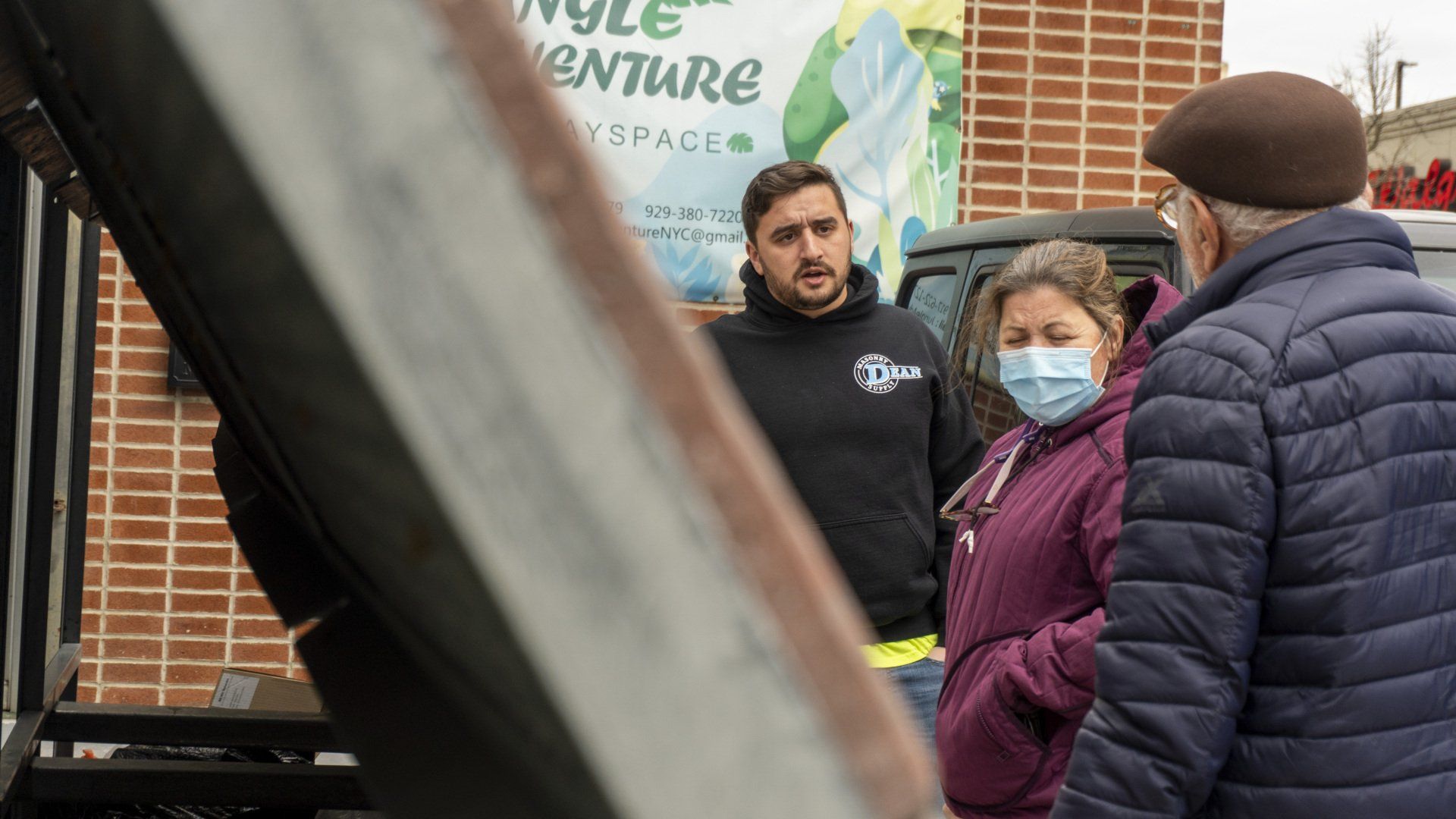 A group of people wearing face masks are standing in front of a truck.