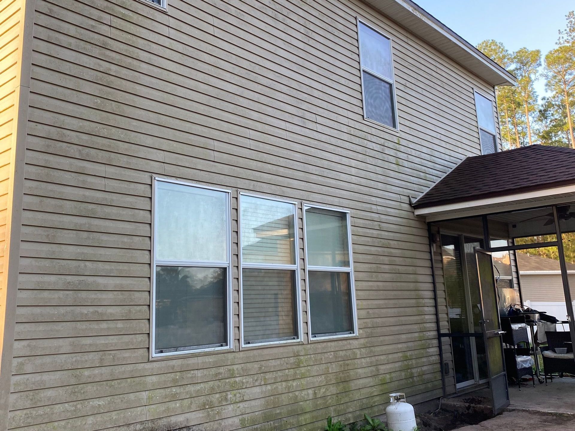 The back of a house with a lot of windows and a porch.