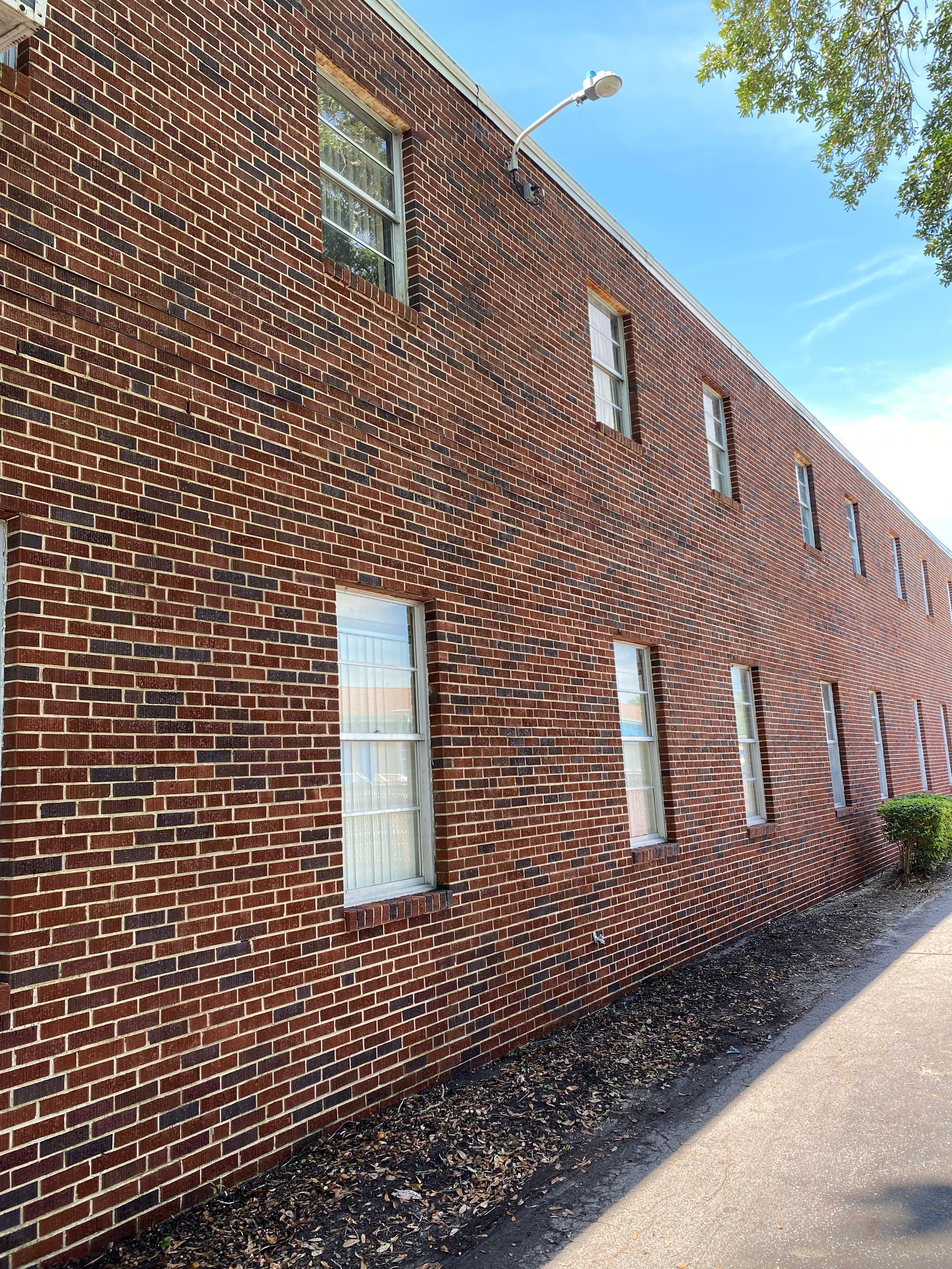 A large brick building with a lot of windows on the side of it.