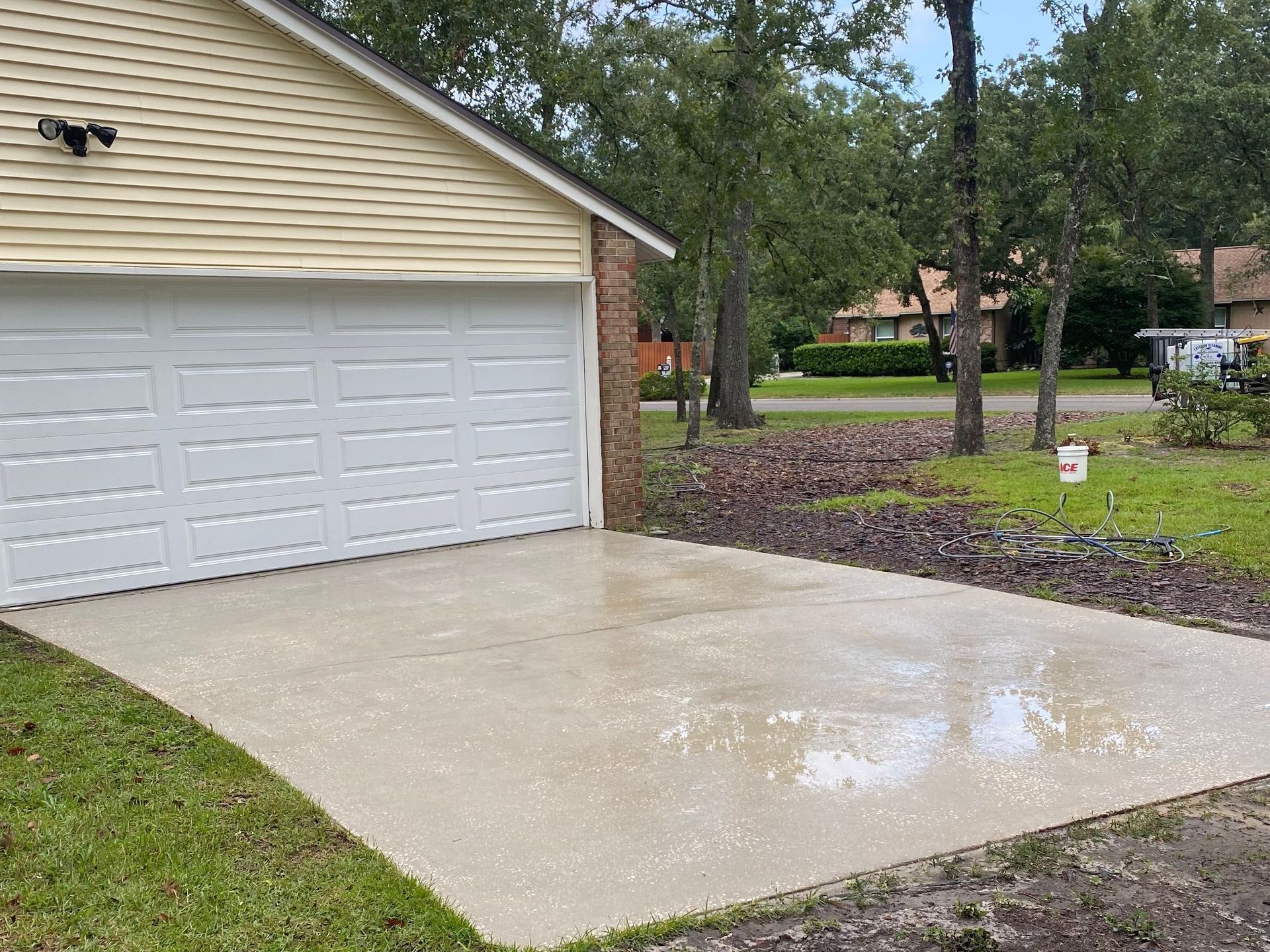 A concrete driveway leading to a garage with a white garage door.