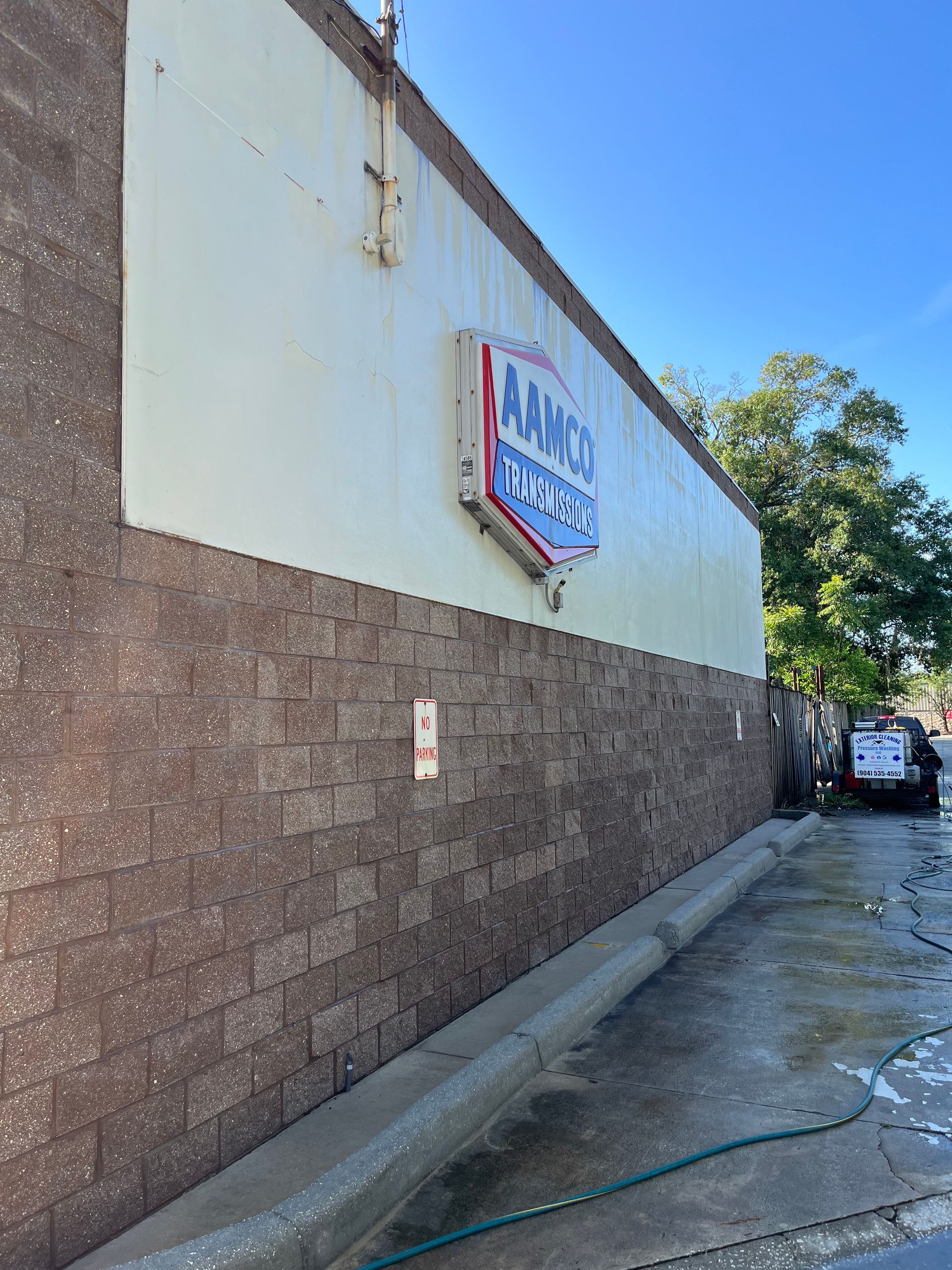 A brick building with a sign on the side that says arms car wash