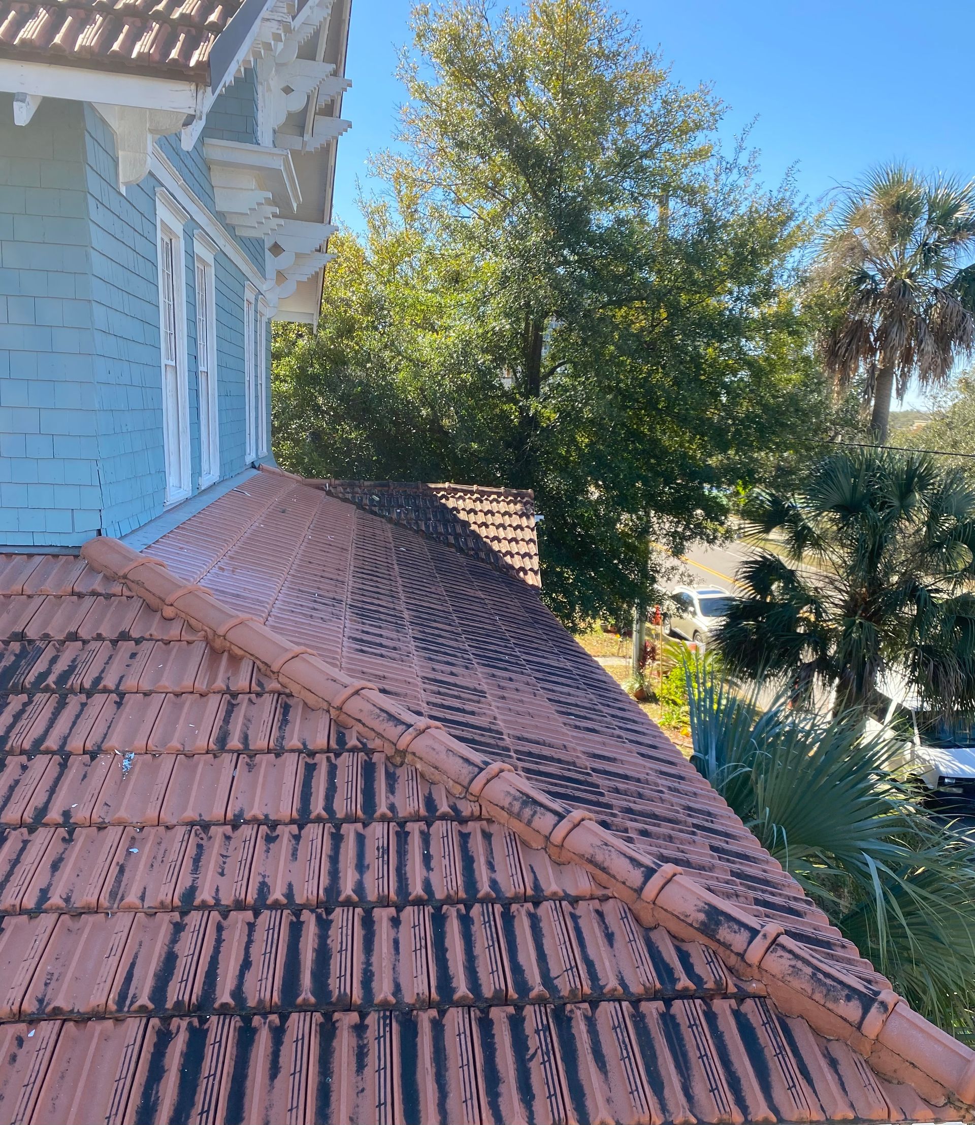 A house with a tiled roof and trees in the background.