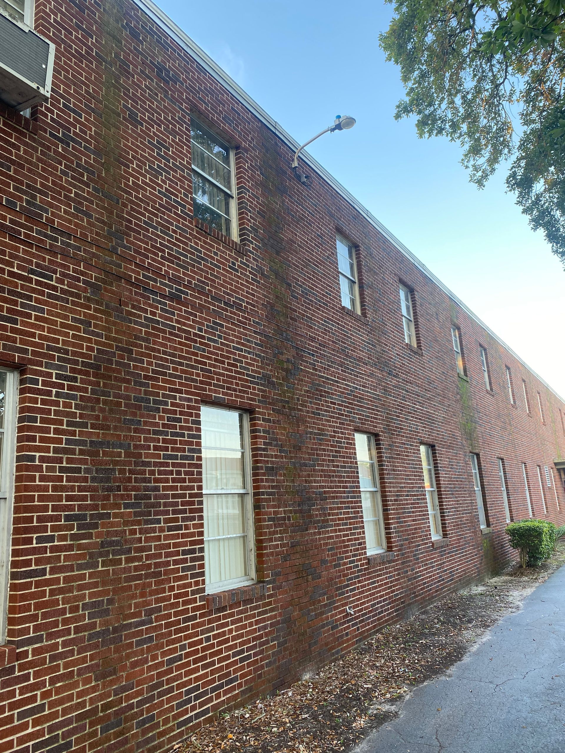 A large brick building with a lot of windows and a street light on the side of it.