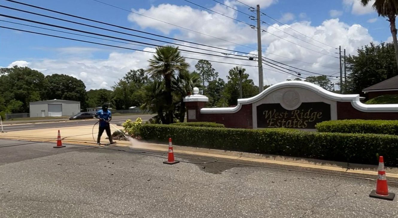 A man is standing on the side of the road in front of a sign.