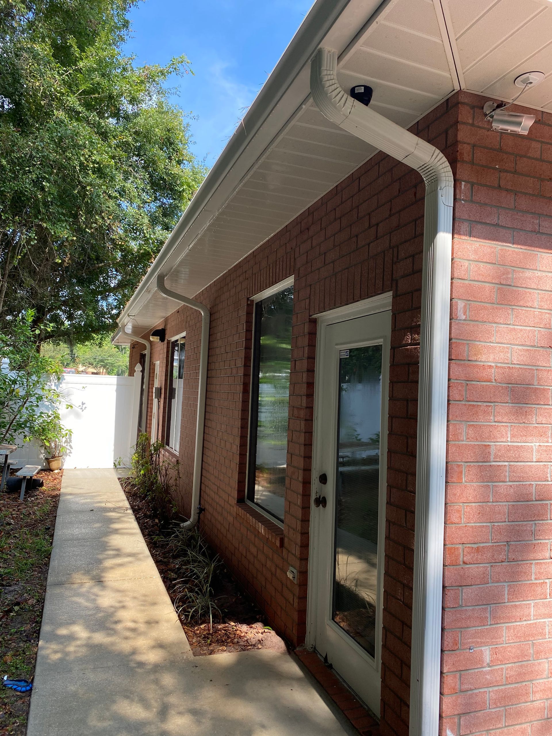 A brick house with a white door and a walkway leading to it.