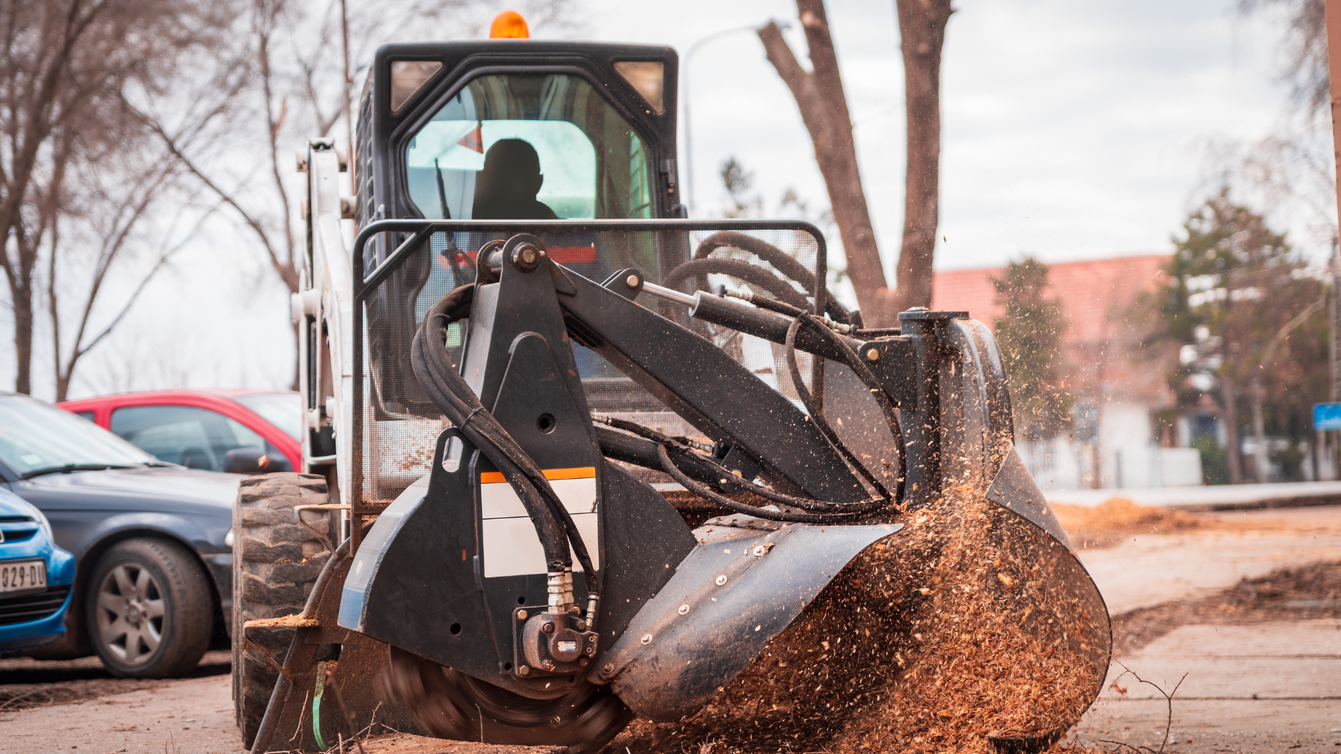 A bulldozer is scooping dirt from a parking lot.