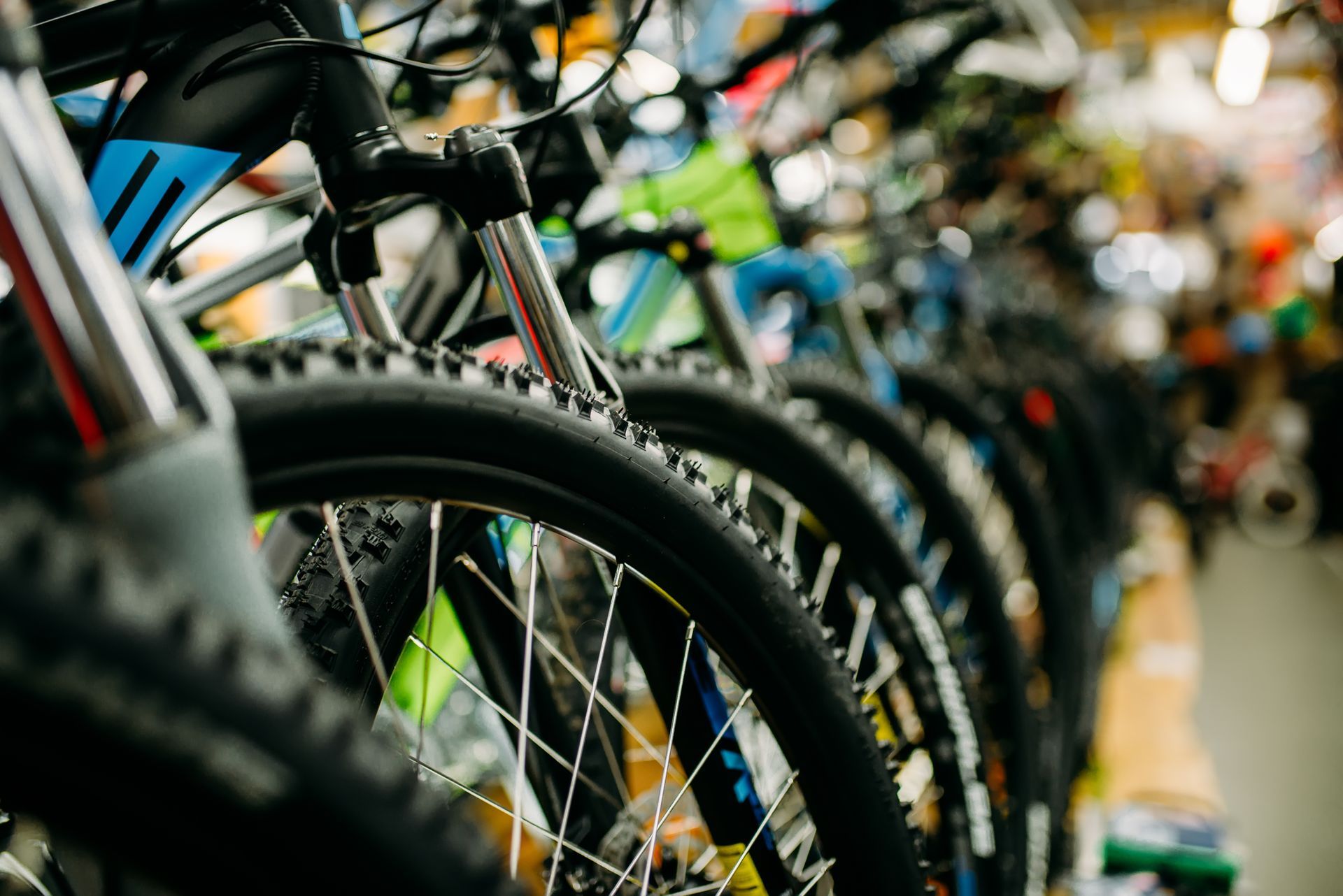 A row of bicycles are lined up in a store.