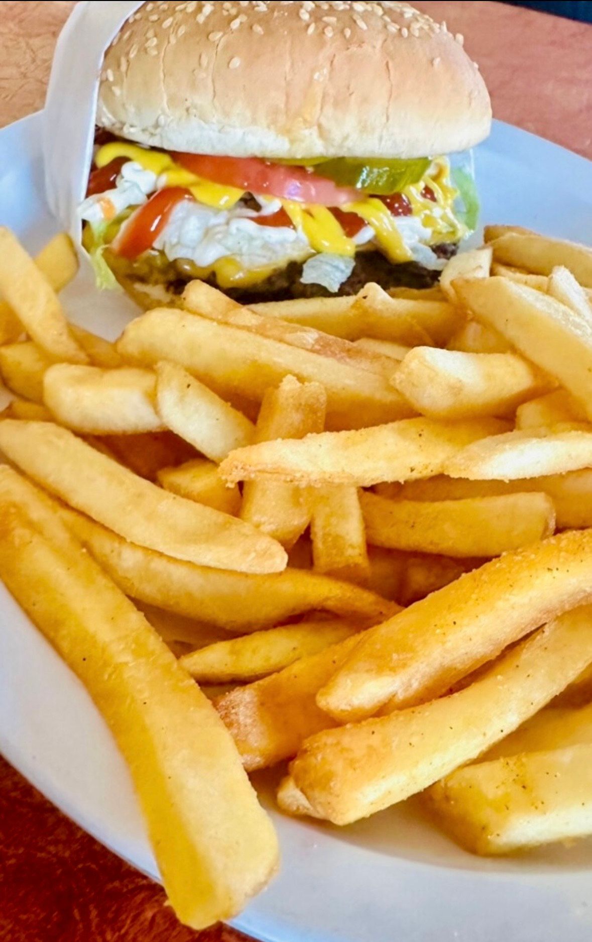 A plate of food with cheese , lettuce and tomatoes on a table.