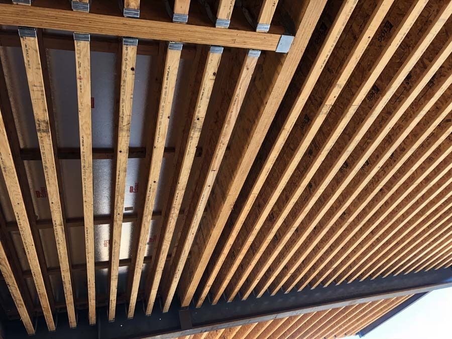 Wooden slatted ceiling with natural wood tones and metal supports.