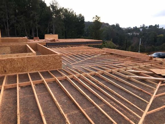Construction site: wooden frame of a building under construction, outdoors.