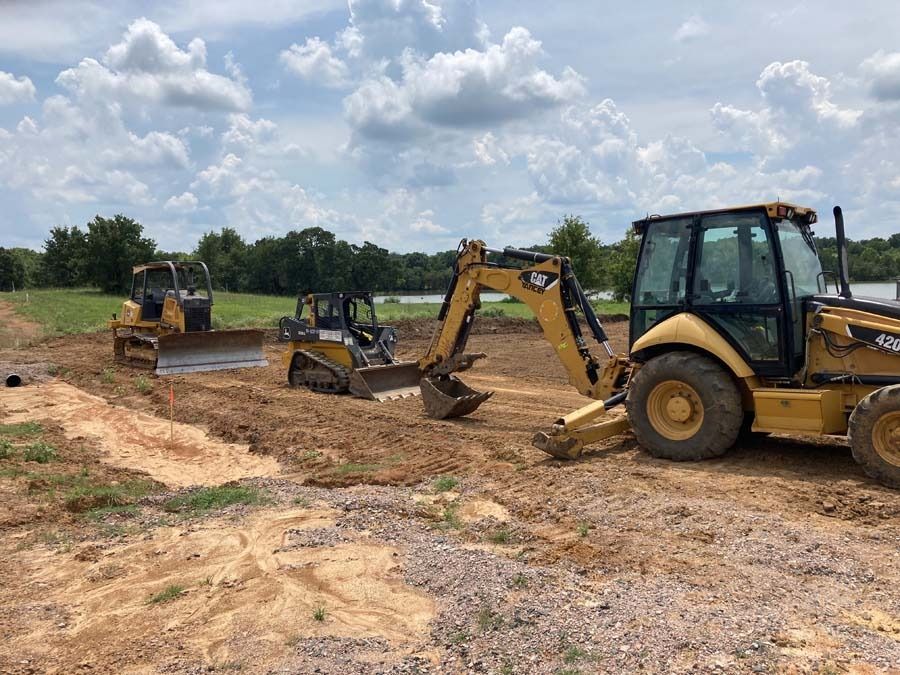 Construction site with yellow excavators and a dozer.