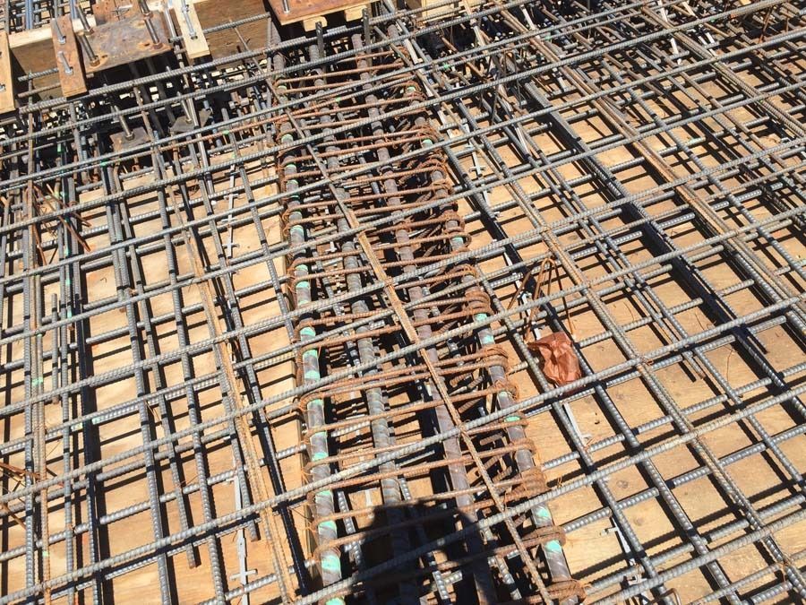 Reinforcement bars in a grid pattern, ready for concrete pouring, on a construction site.