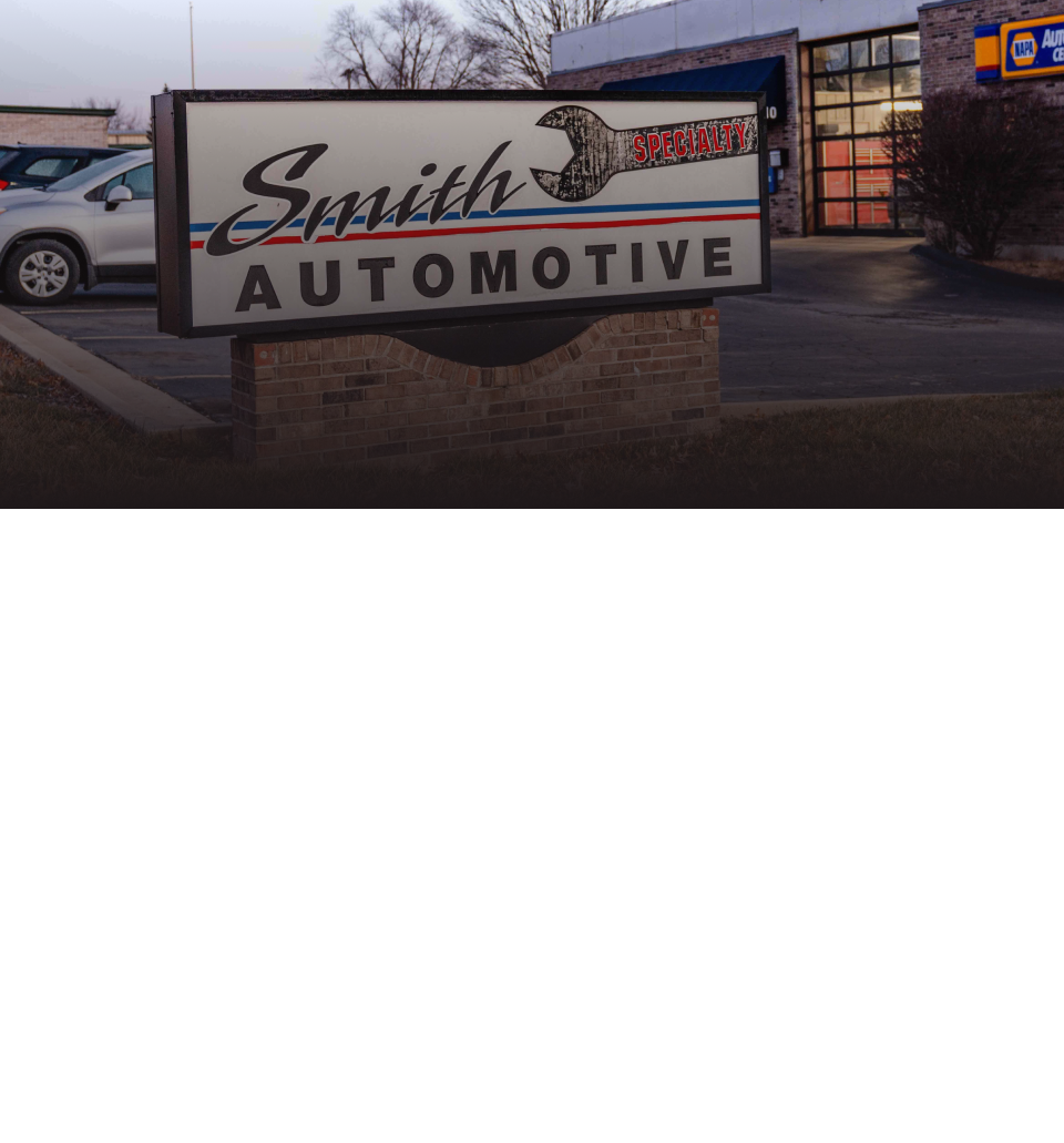 A sign for smith automotive is in front of a garage | Smith Specialty Automotive
