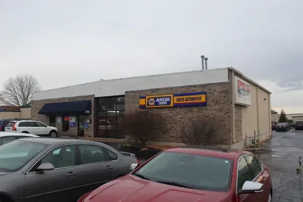 A red car is parked in front of a building