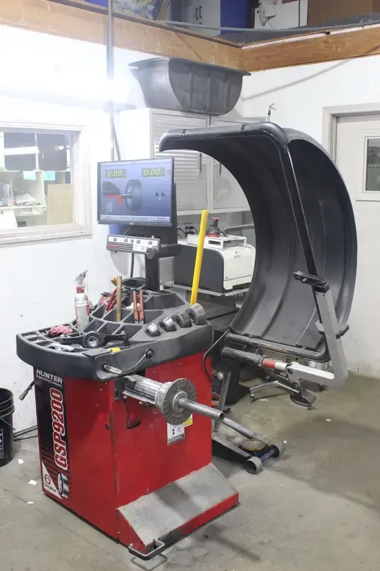 A tire balancing machine is sitting in a garage