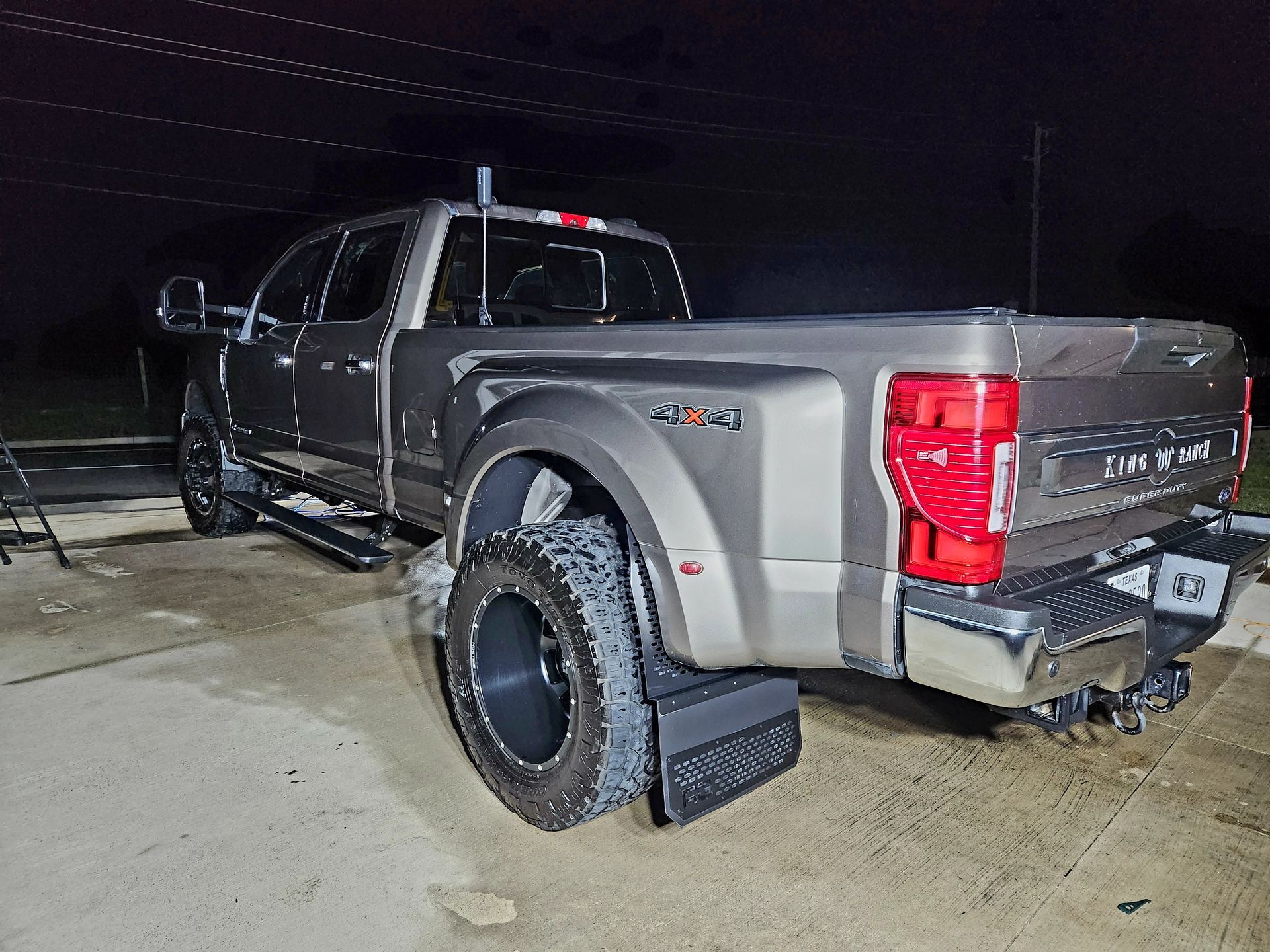 A large, gray Ford F-350 pickup truck parked outside at night.