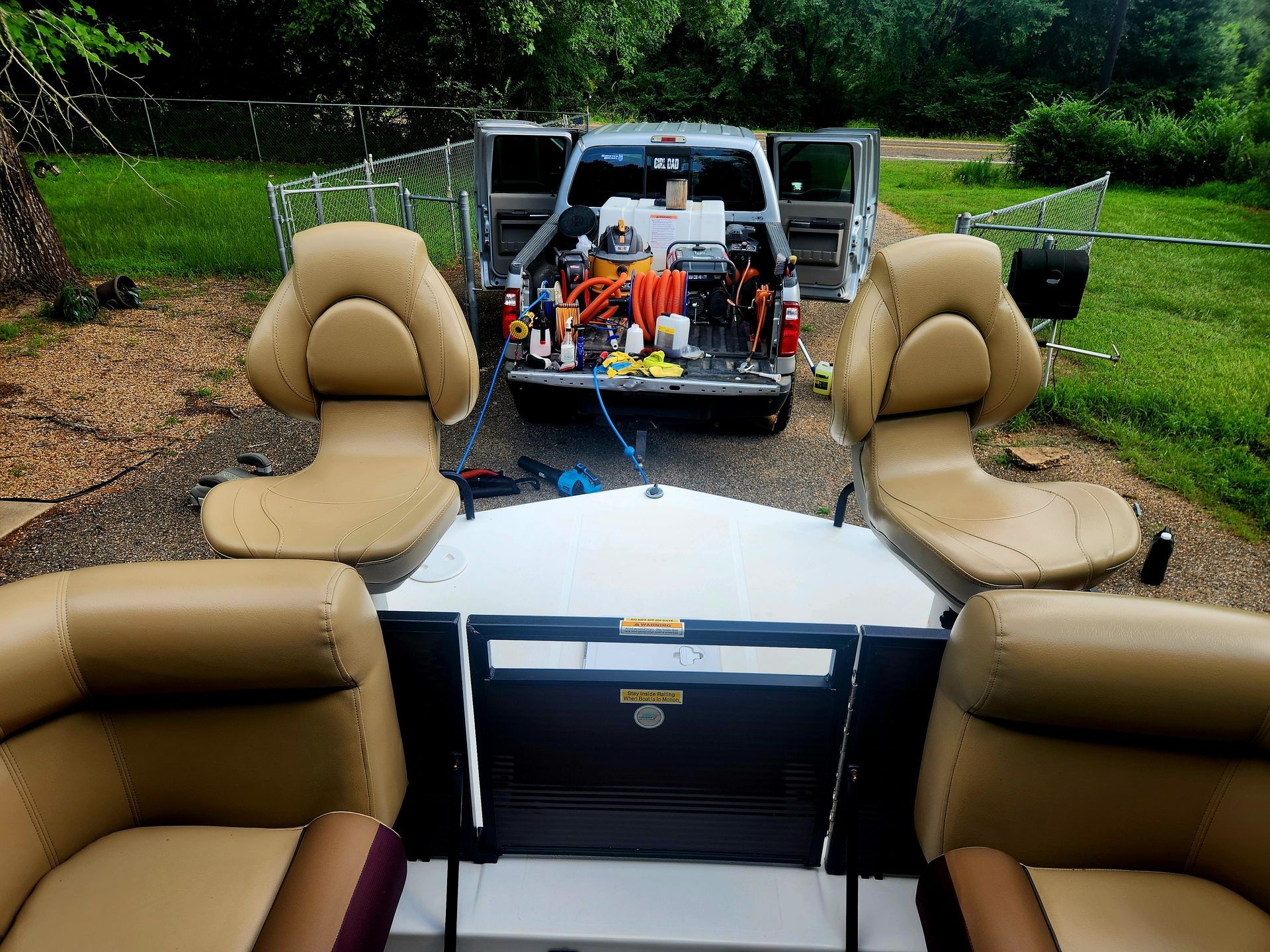 Boat seats in front of open pickup truck with cleaning supplies.