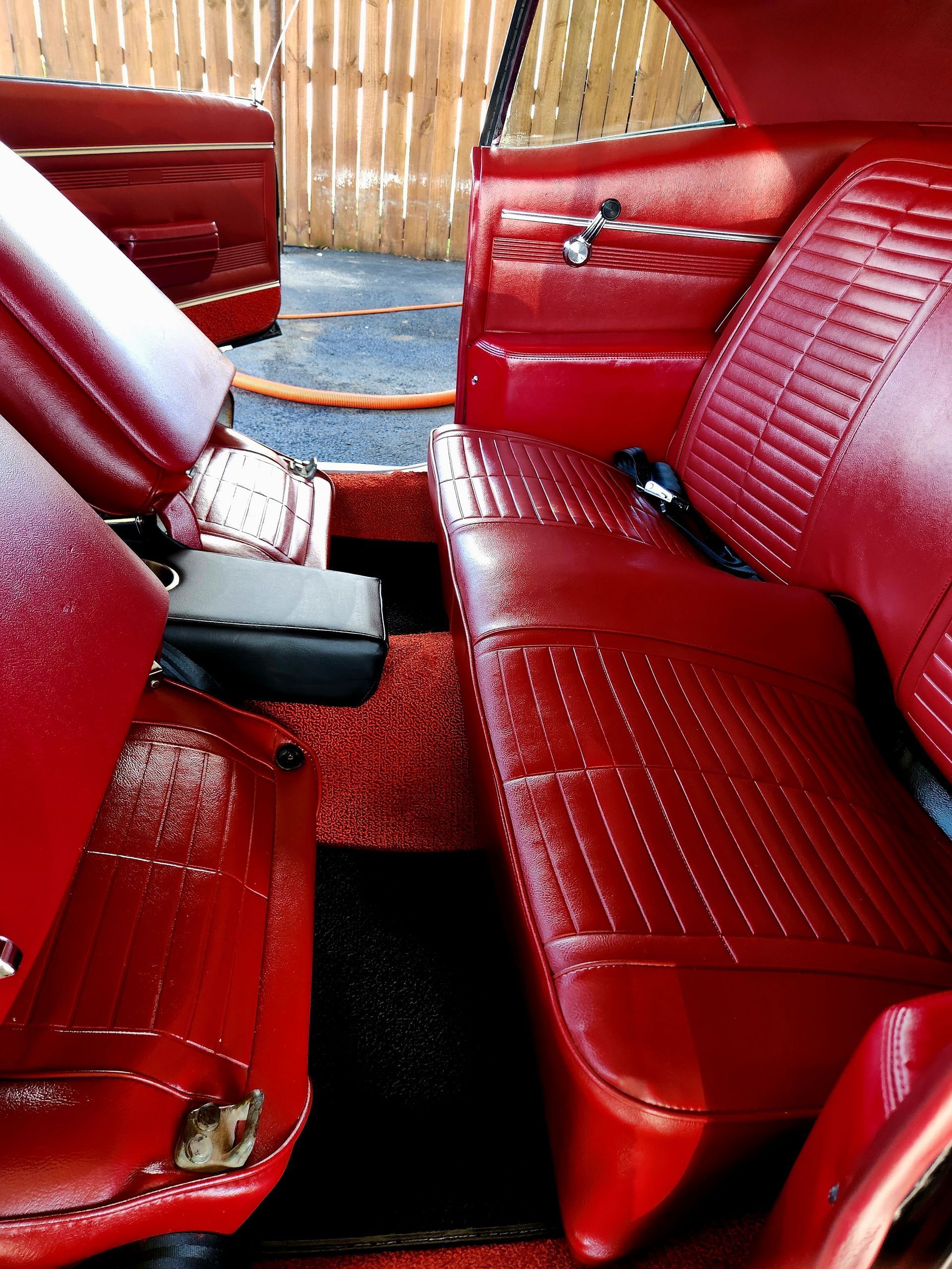 Red interior of a classic car, including seats, dashboard, and carpet.