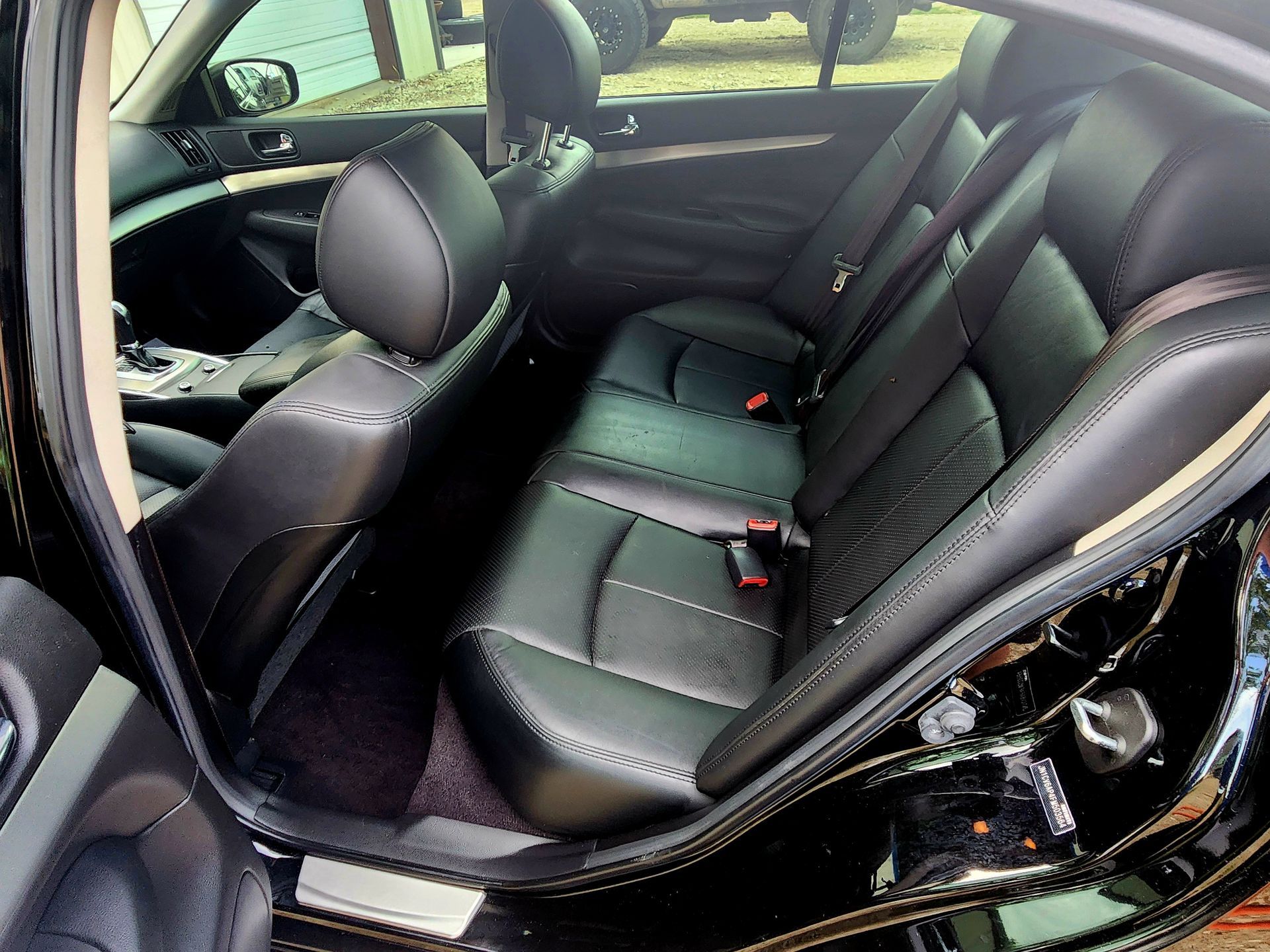 Black leather car interior with rear seats.