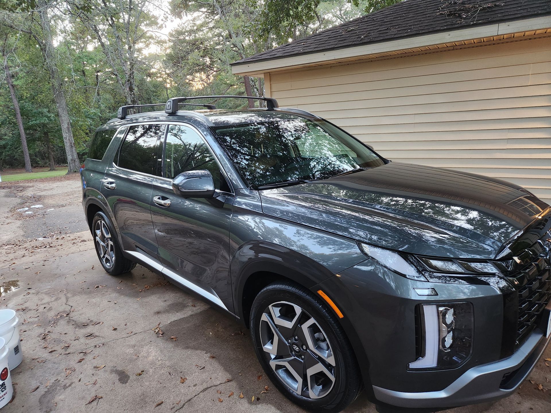 Gray Hyundai Palisade SUV parked outside with a roof rack.