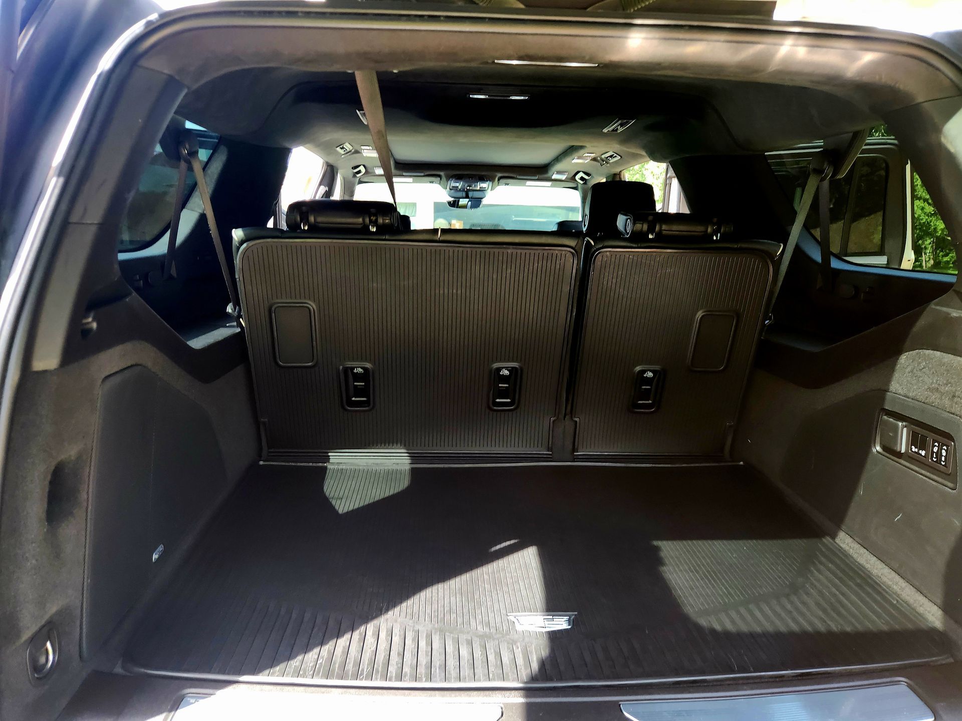 Empty SUV cargo area with dark interior and protective mat.