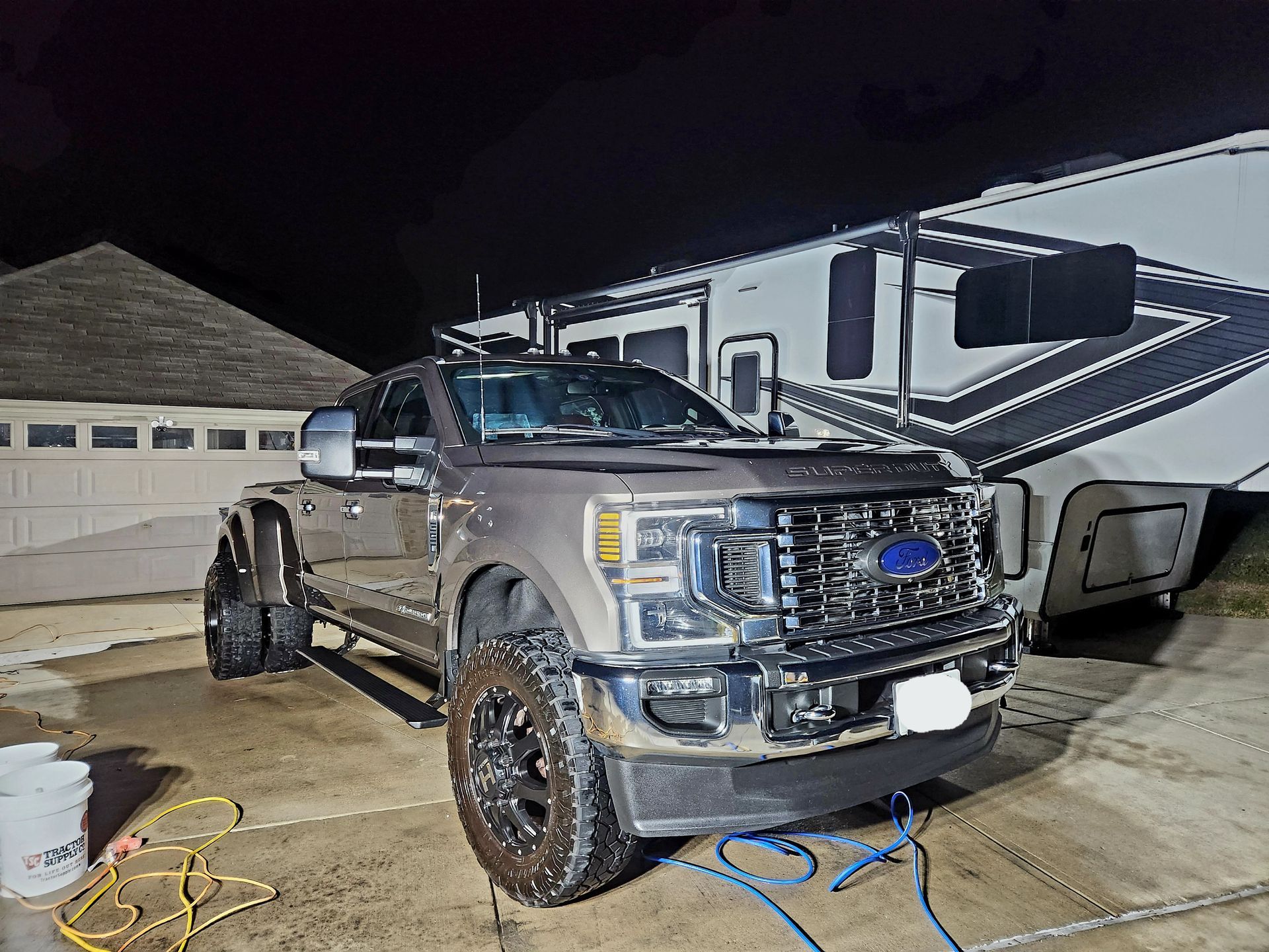 A large brown Ford truck is parked in front of a trailer, with soapsuds visible.