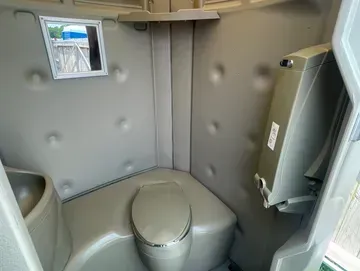 A bathroom with a toilet , sink and mirror.