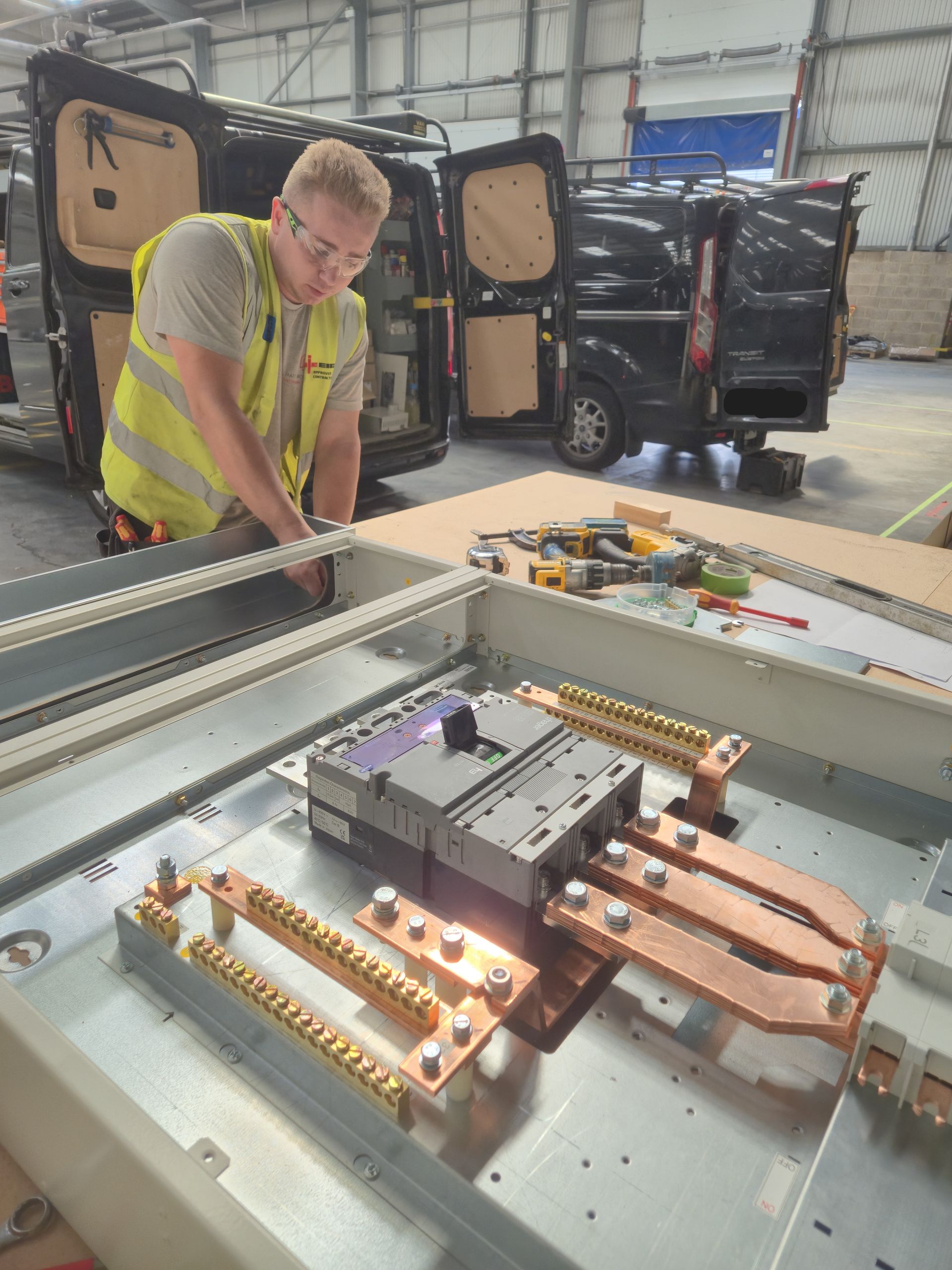 An NICEIC Approved Contractor electrician from Matt Browning Electrical assembling a Hager UK 630A panelboard with MCCB main switch as part of an electrical fit-out project at an industrial warehouse & factory near Slough & Reading.