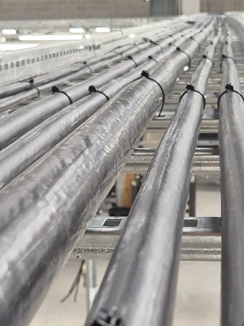 This image shows steel wire armoured industrial power cables installed and neatly tied in on a galvanised steel cable ladder system at high level in a factory to feed electrical supplies to industrial machines and building services plant. The experienced electricians at Matt Browning Electrical offer this installation service for commercial and industrial buildings like this one near Reading in Berkshire, and they can provide full design and detailed quotes.