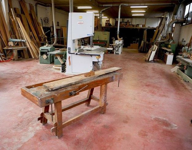 Tavolo da falegname del '900 e moderni macchinari da falegname all'interno del laboratorio