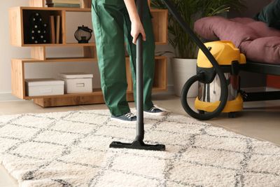 Worker Cleaning Area Rug