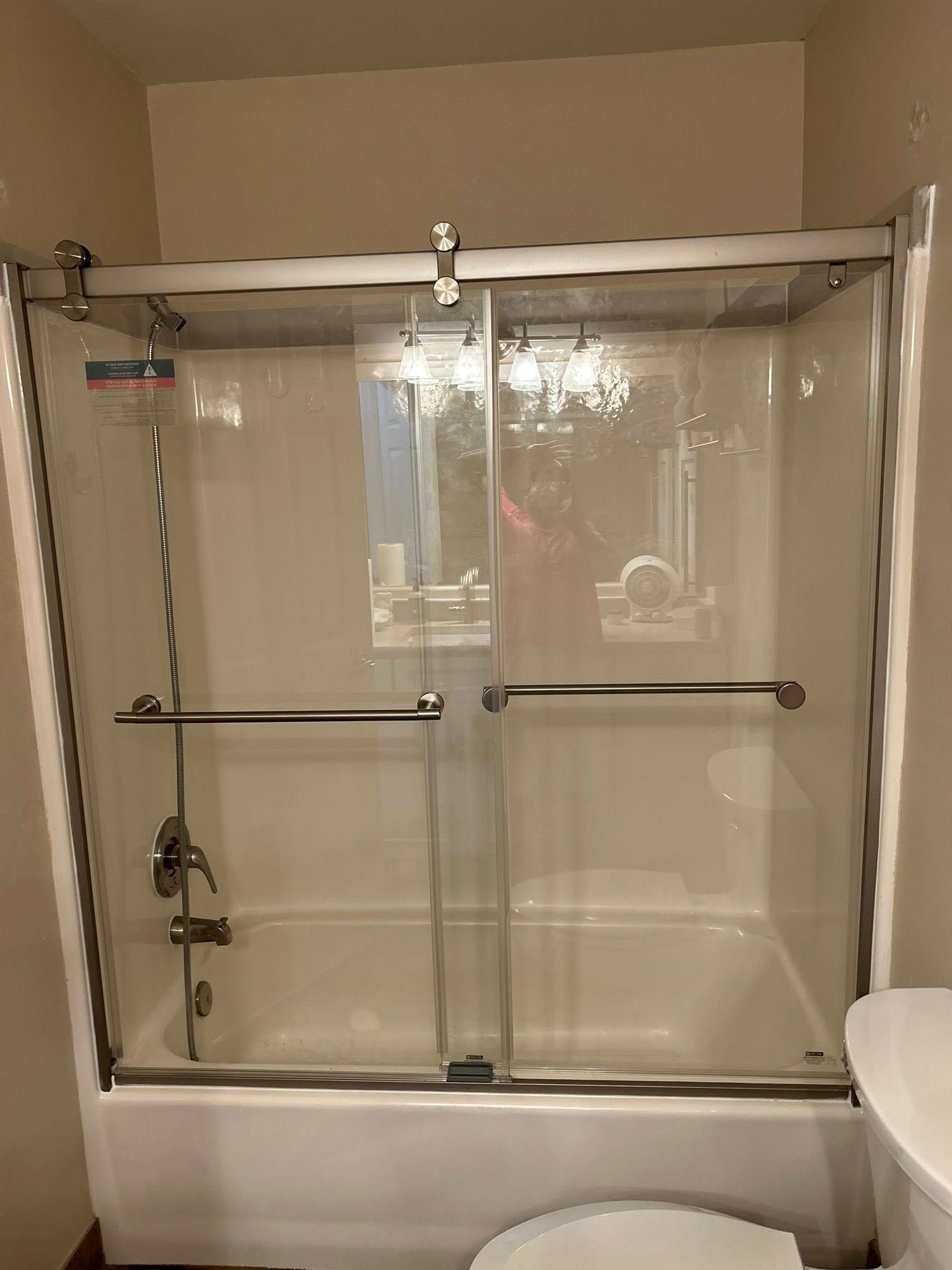 A white bathroom with a glass shower door.