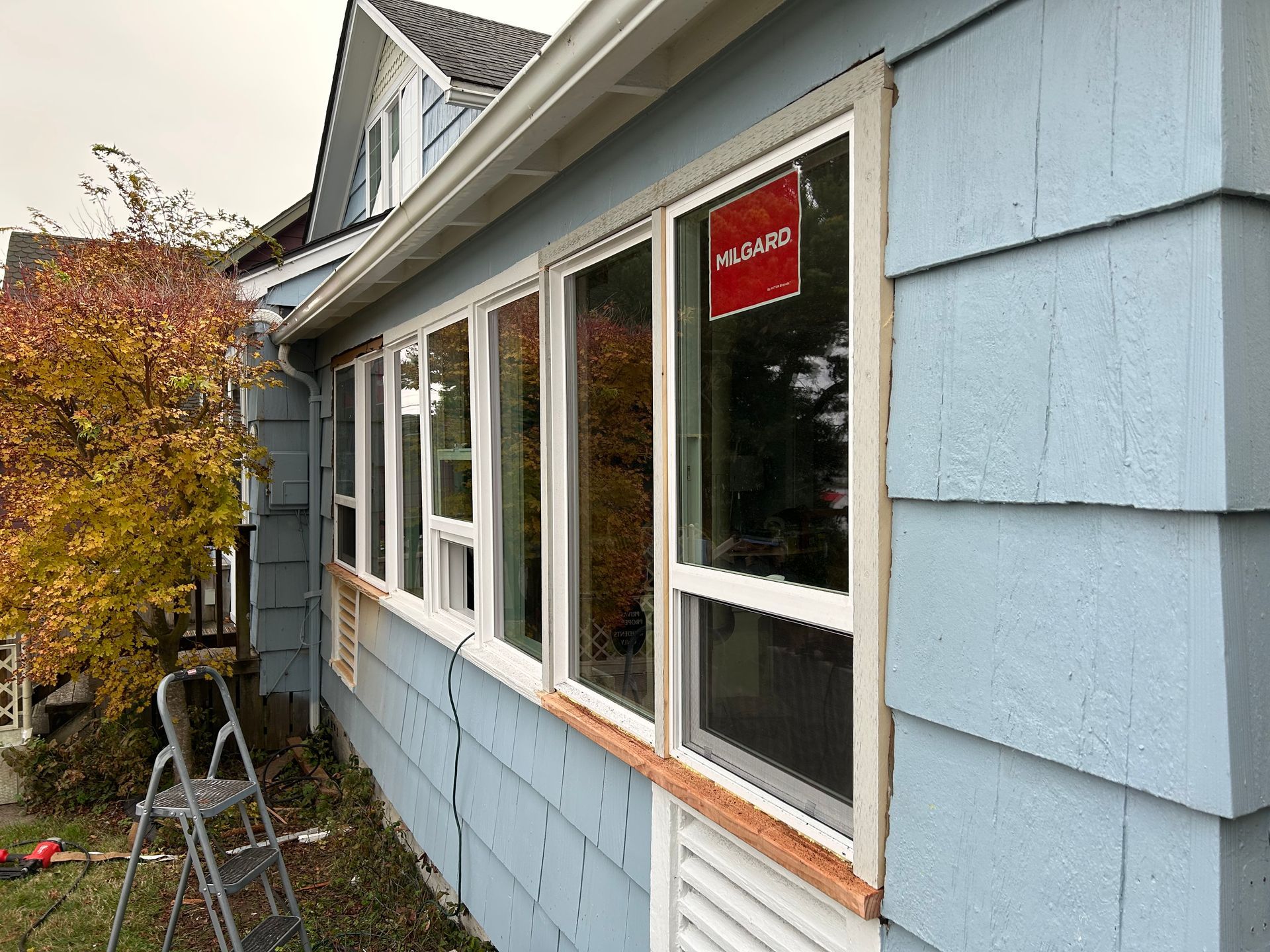 Exterior of a house with several windows, light blue siding.