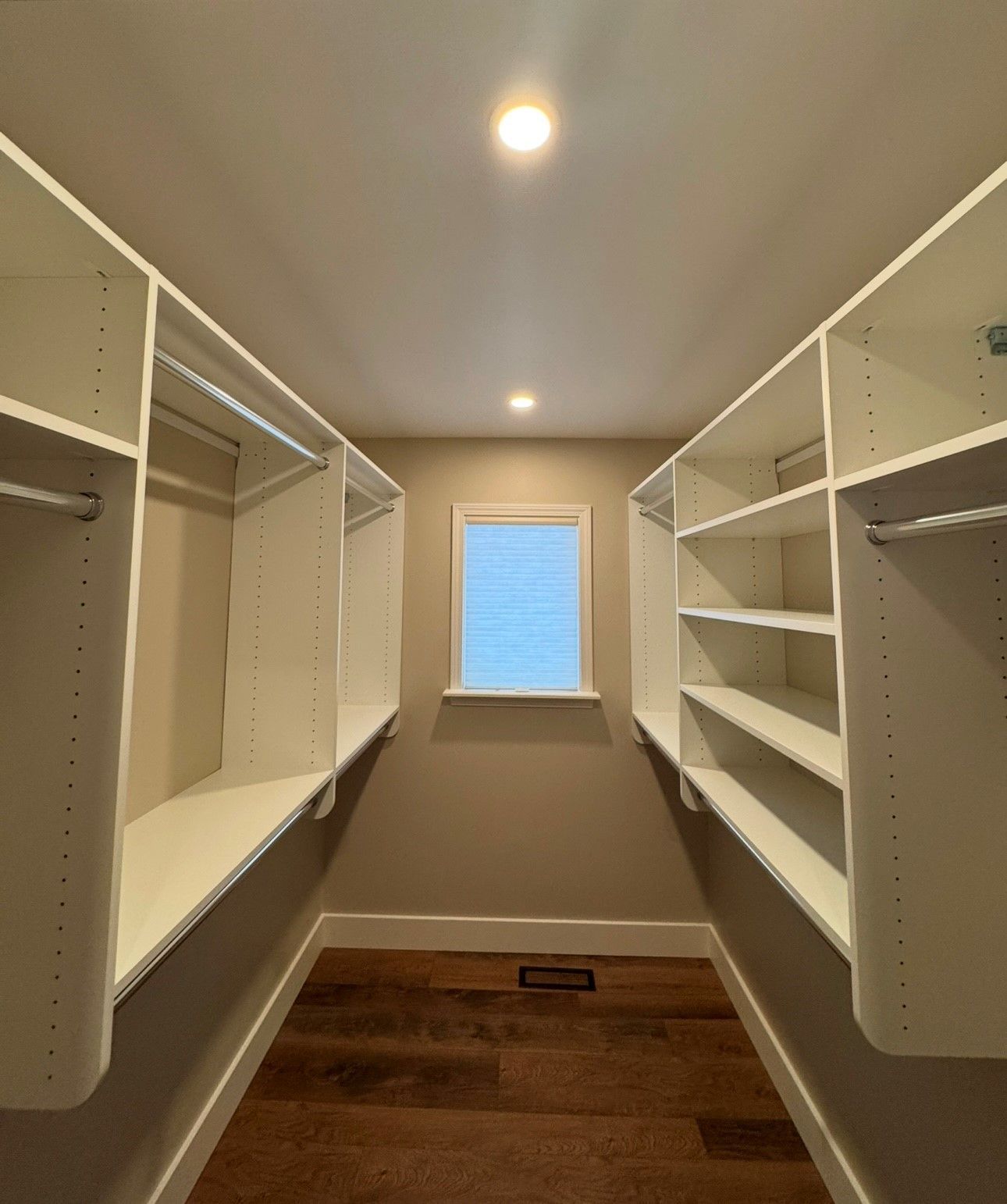 A walk in closet with lots of shelves and a window