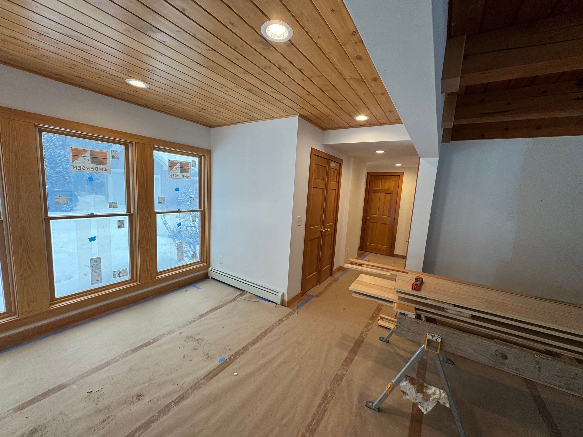 An empty room with a wooden ceiling and lots of windows.