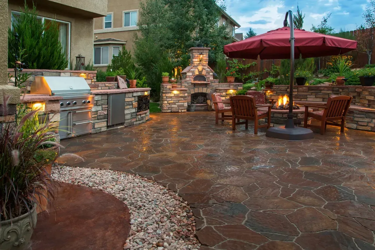 There is a red umbrella in the middle of the patio.