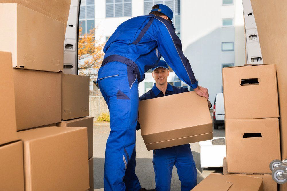 Two Men Are Loading Boxes Into A Van — LEA Distribution In Gulgong, NSW