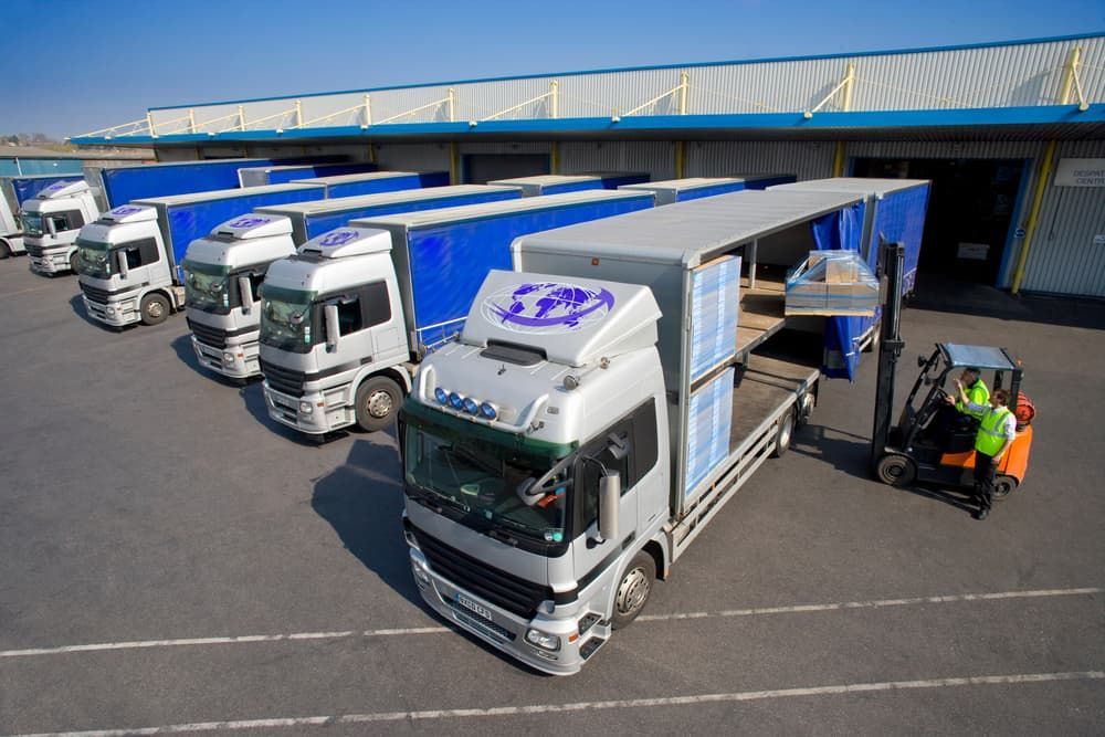 A Row Of Trucks Are Parked In Front Of A Building — LEA Distribution In Wellington, NSW