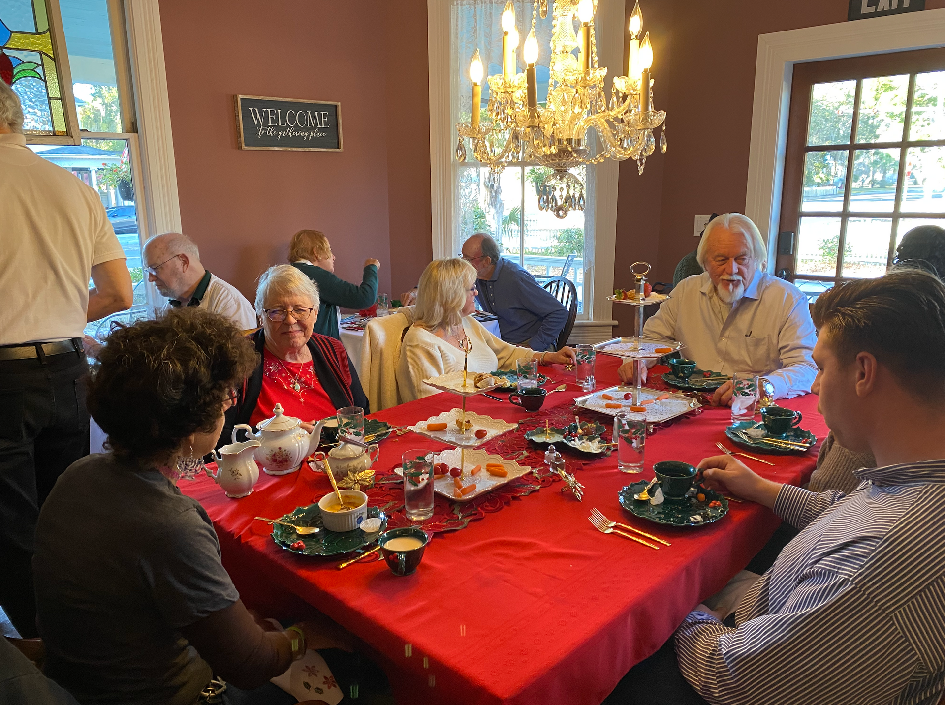 A group of happy people enjoying tea in the dining room at The Camellia Rose Inn.