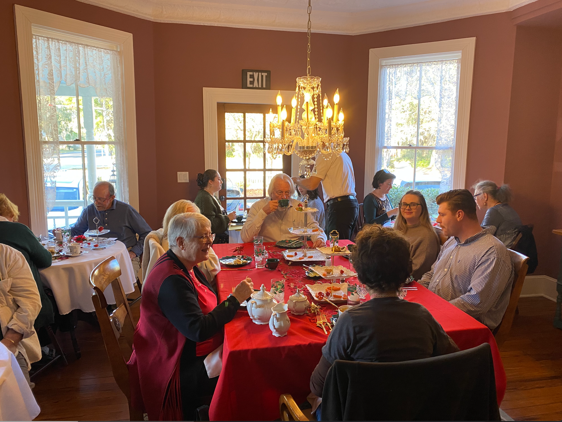 A group of people happily enjoying the Afternoon Tea at The Camellia Rose Inn