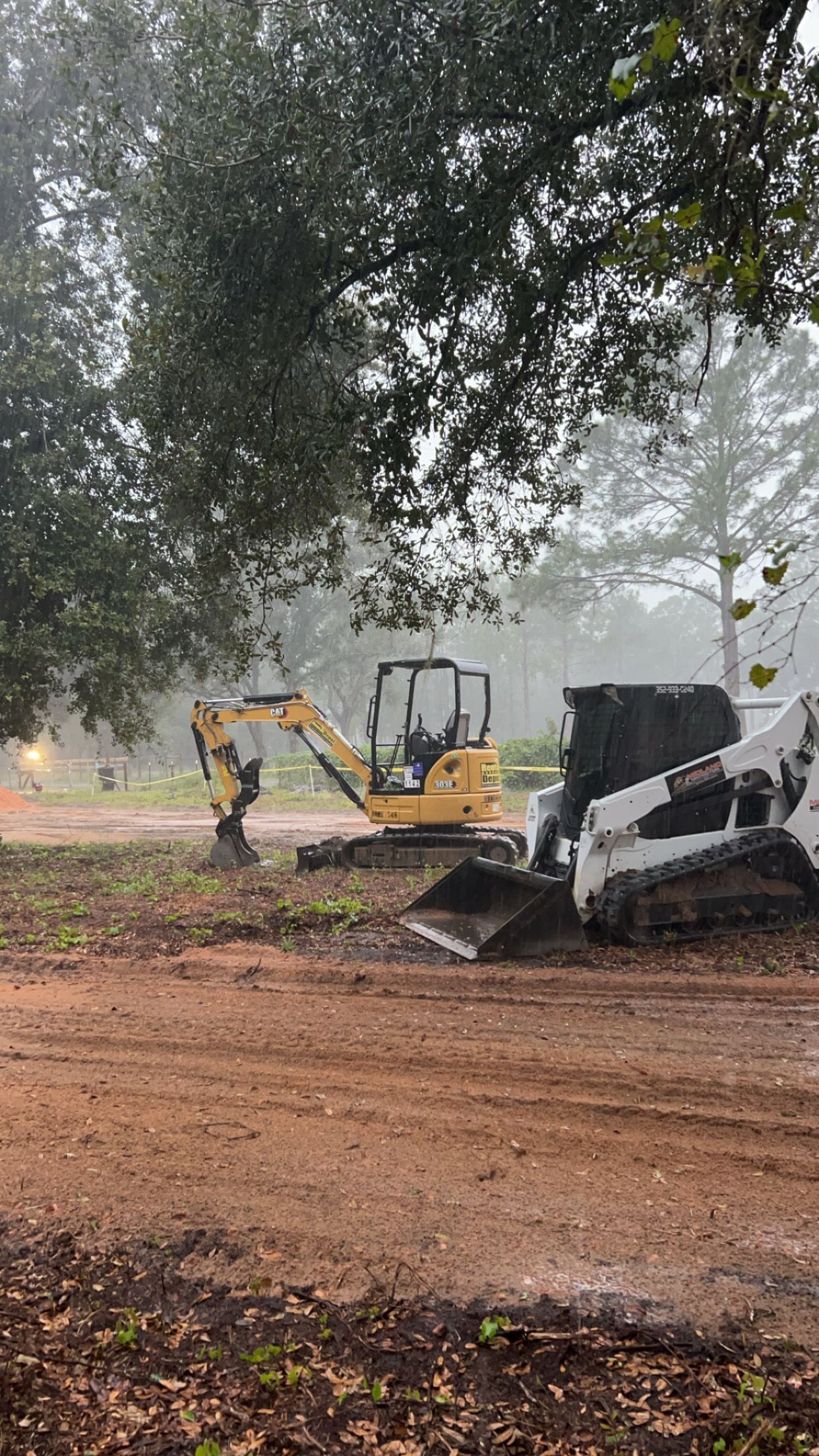 A bulldozer and an excavator are working on a dirt road. - Midland Contractors - Clermont, FL
