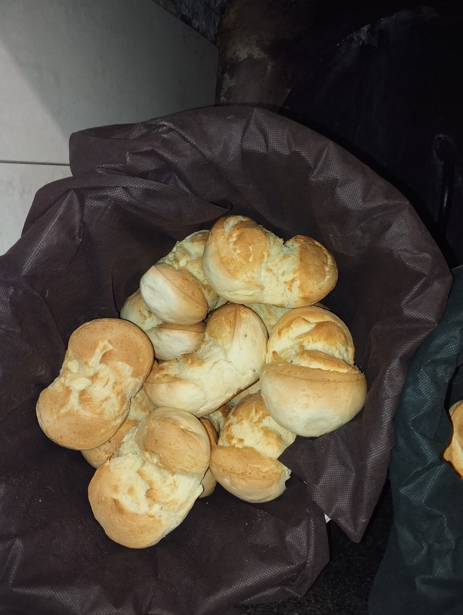 Un cestino traboccante di panini dorati a forma di pretzel.