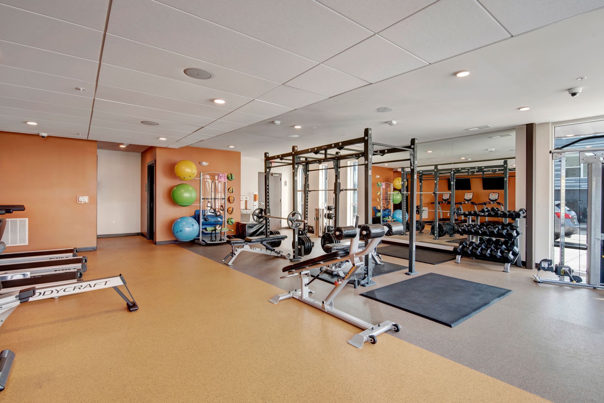 A large gym with a lot of equipment and a lot of mirrors.